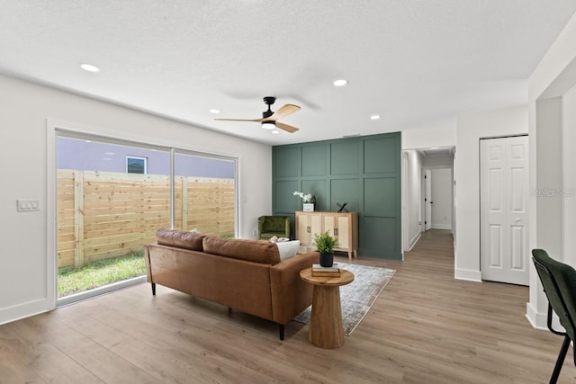 living room featuring a textured ceiling, light hardwood / wood-style floors, and a healthy amount of sunlight