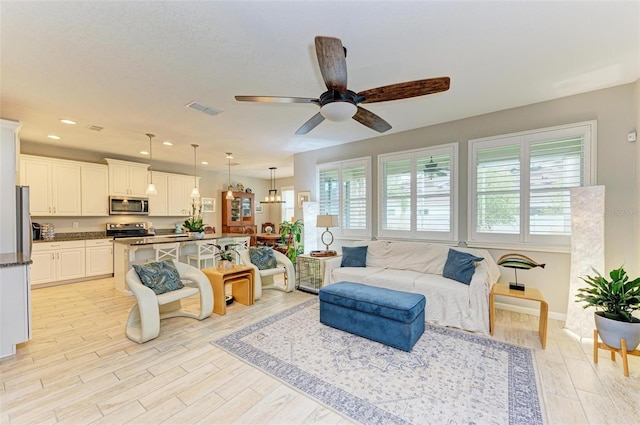 living room featuring ceiling fan and light hardwood / wood-style floors