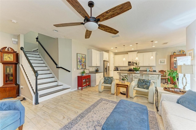 living room featuring ceiling fan and light wood-type flooring