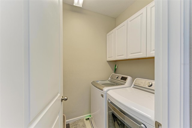 laundry area featuring washing machine and dryer and cabinets