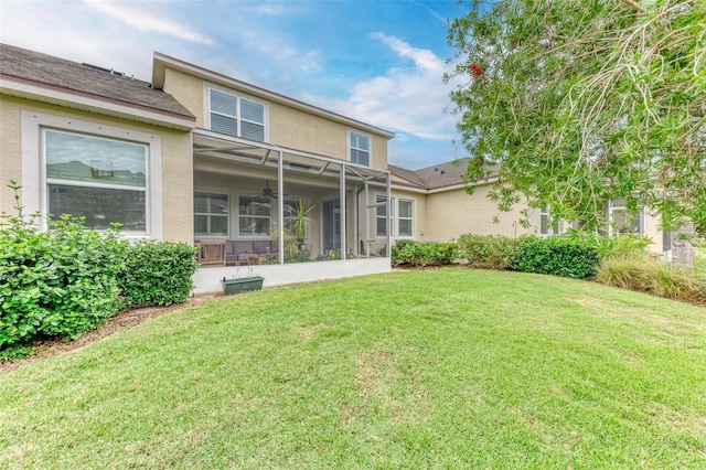 rear view of house featuring a lanai and a lawn