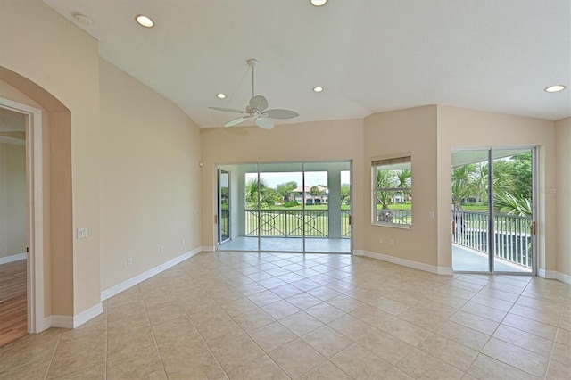 tiled empty room featuring vaulted ceiling and ceiling fan