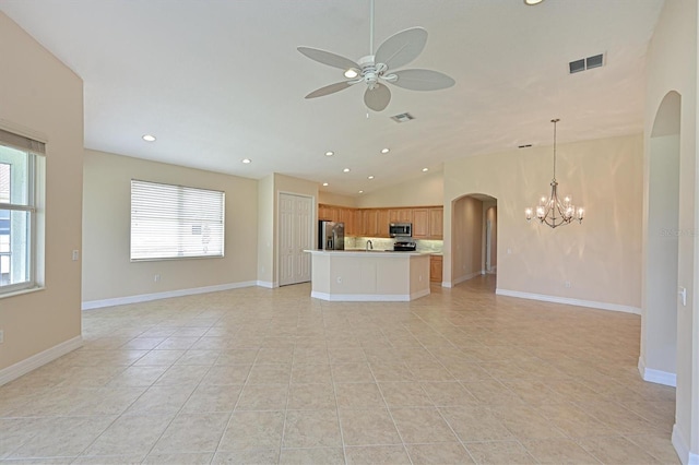 unfurnished living room with ceiling fan with notable chandelier, light tile patterned floors, a wealth of natural light, and lofted ceiling