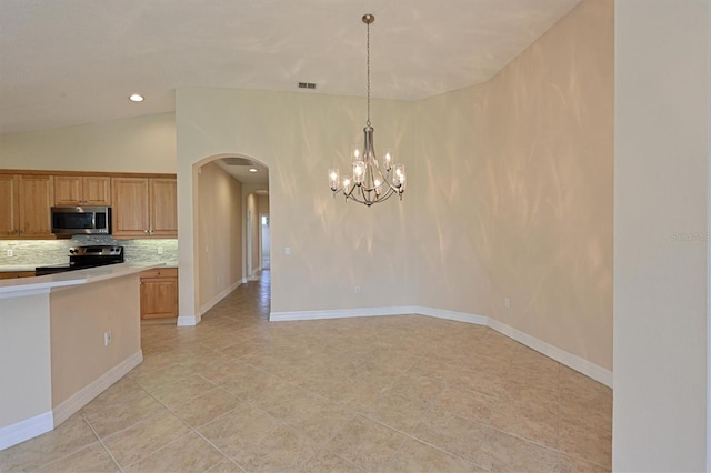 kitchen featuring an inviting chandelier, tasteful backsplash, lofted ceiling, decorative light fixtures, and appliances with stainless steel finishes