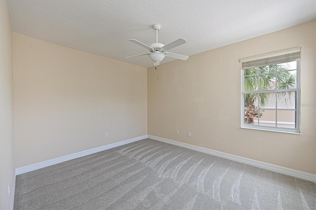 empty room featuring ceiling fan, carpet floors, and a textured ceiling