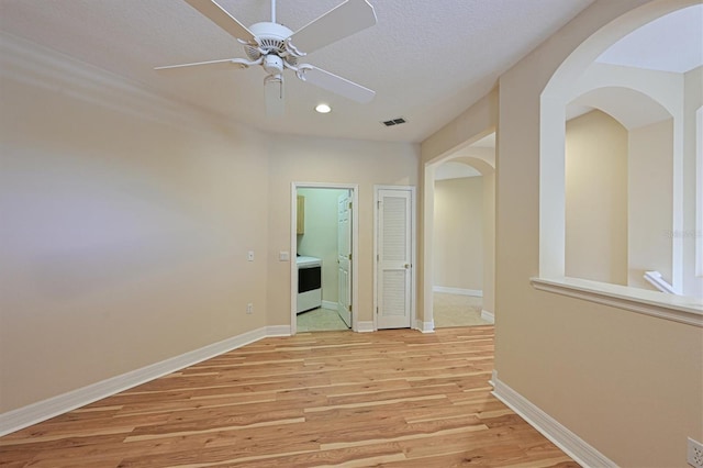 corridor with light hardwood / wood-style flooring and a textured ceiling