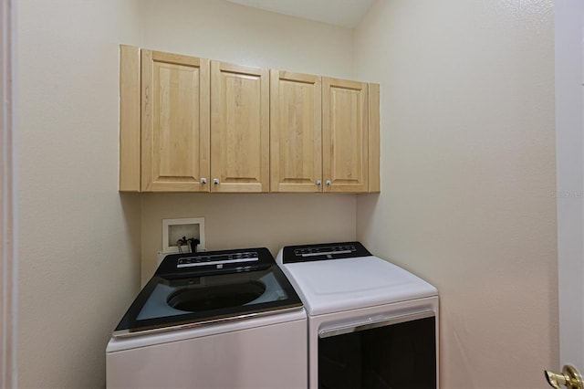 washroom with washing machine and dryer and cabinets