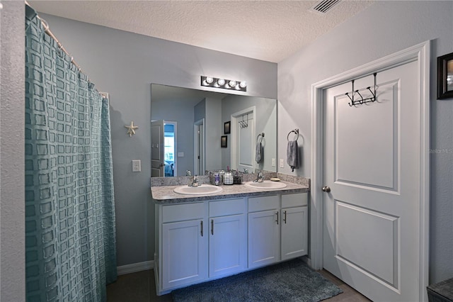 bathroom with vanity and a textured ceiling