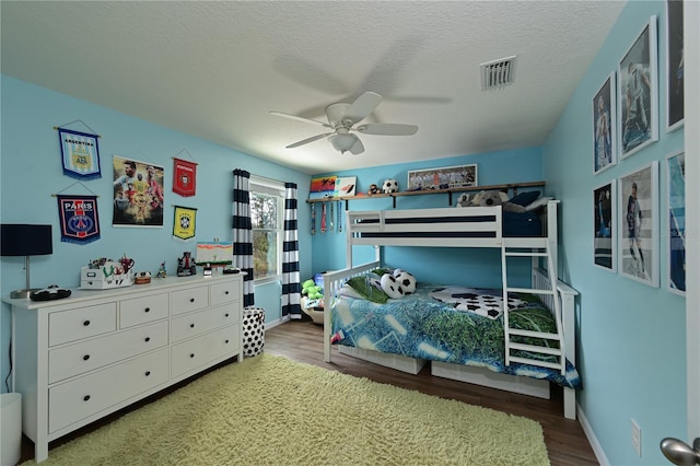 bedroom featuring ceiling fan, hardwood / wood-style floors, and a textured ceiling