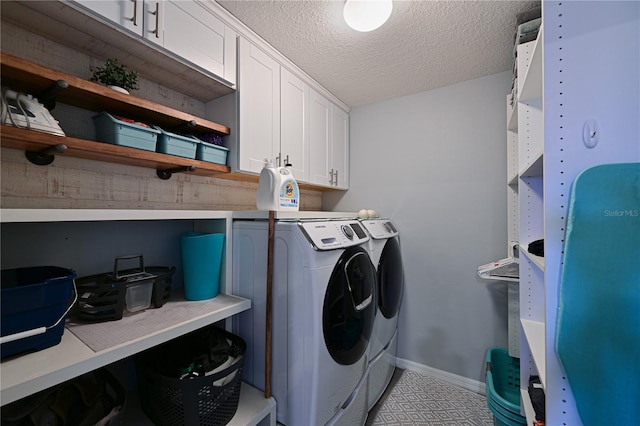 laundry area featuring cabinets, washing machine and dryer, and a textured ceiling