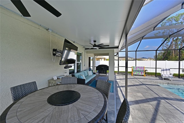 view of patio with glass enclosure, ceiling fan, and an outdoor hangout area