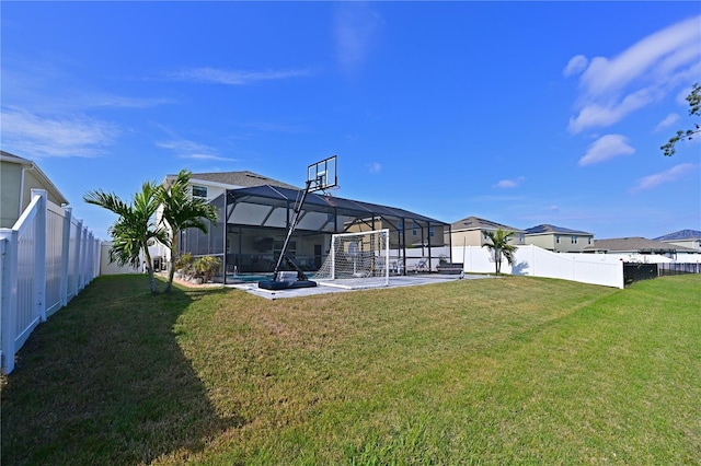 rear view of property with a yard, glass enclosure, and a patio area