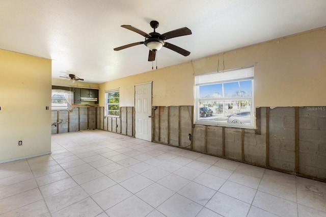 tiled spare room with ceiling fan