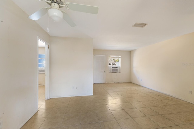 tiled spare room with ceiling fan and cooling unit