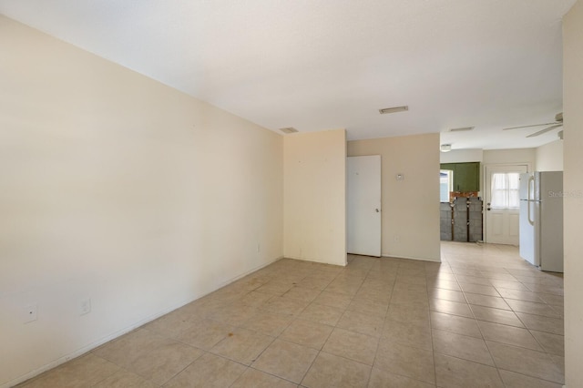 spare room featuring ceiling fan and light tile patterned floors