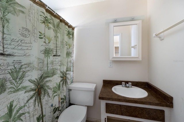 bathroom with curtained shower, vanity, and toilet