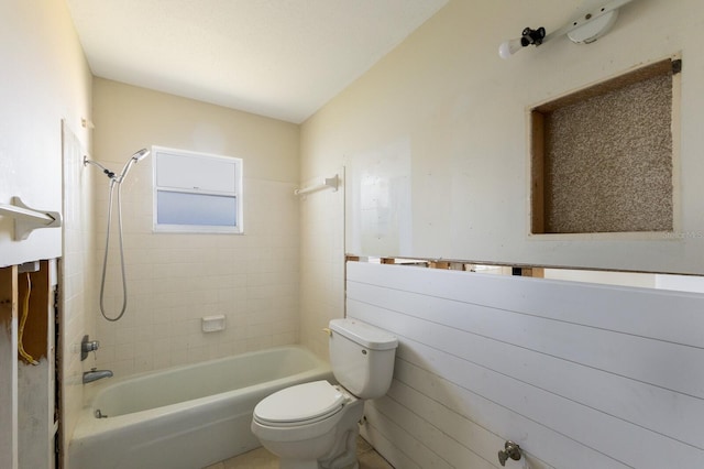 bathroom featuring toilet and tiled shower / bath