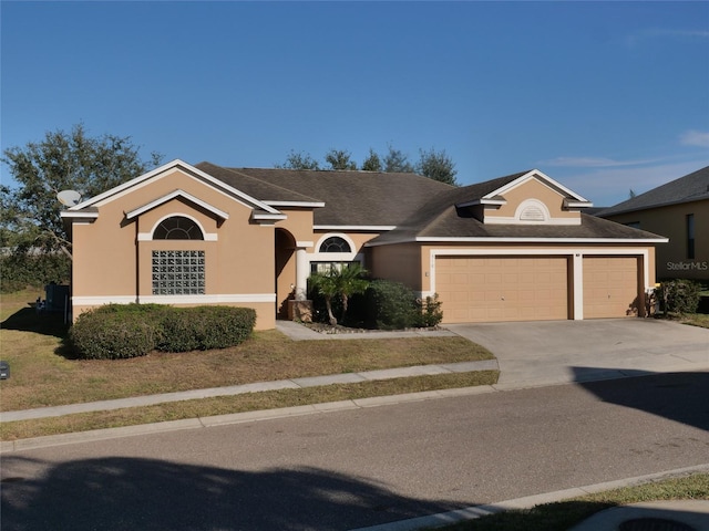 ranch-style home featuring stucco siding, concrete driveway, and a garage