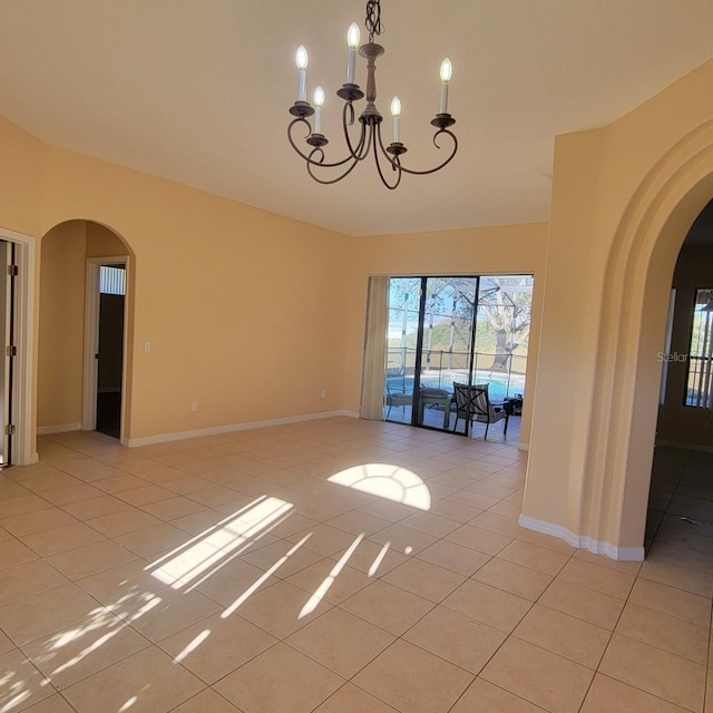 unfurnished room with a notable chandelier and light tile patterned floors