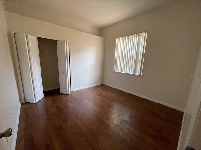 unfurnished bedroom featuring a closet and dark hardwood / wood-style floors