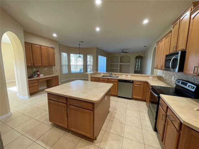 kitchen with decorative light fixtures, kitchen peninsula, appliances with stainless steel finishes, and backsplash