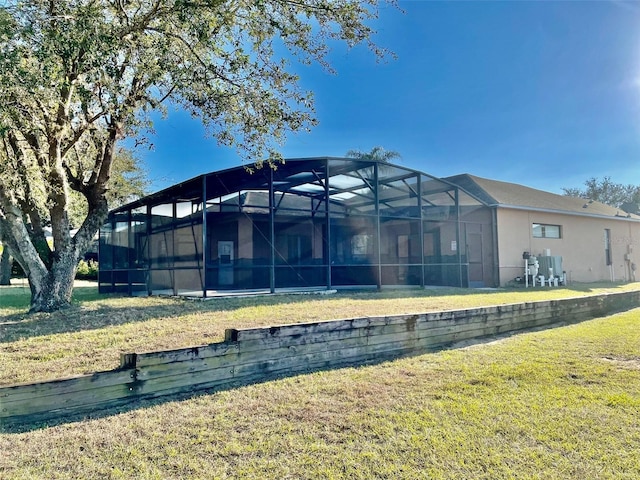 back of property featuring a lawn and a lanai