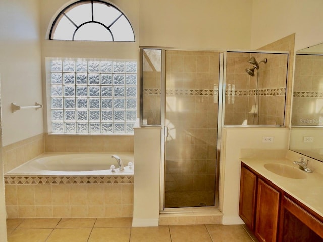 full bathroom featuring a healthy amount of sunlight, tile patterned floors, vanity, and a stall shower