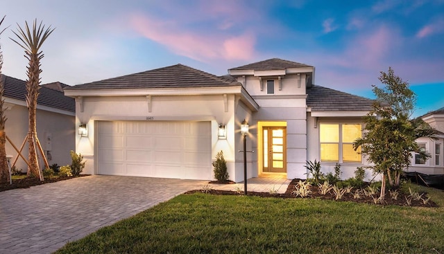 prairie-style home with a garage and a yard