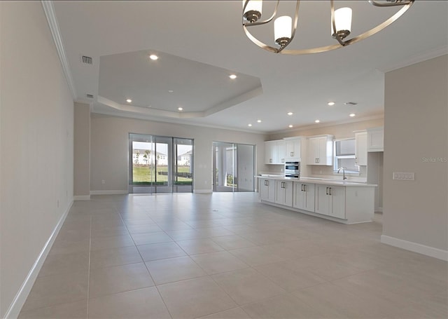 unfurnished living room featuring sink, a raised ceiling, crown molding, a chandelier, and light tile patterned flooring