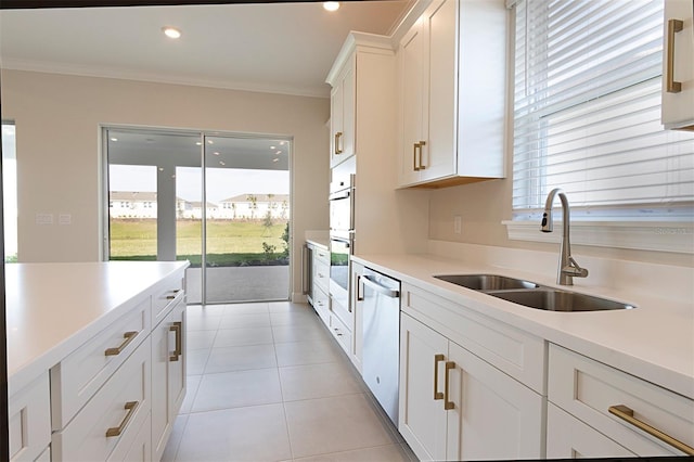 kitchen featuring white cabinetry, dishwasher, sink, light tile patterned floors, and ornamental molding