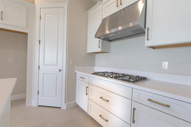 kitchen with white cabinets, light tile patterned flooring, and stainless steel gas cooktop