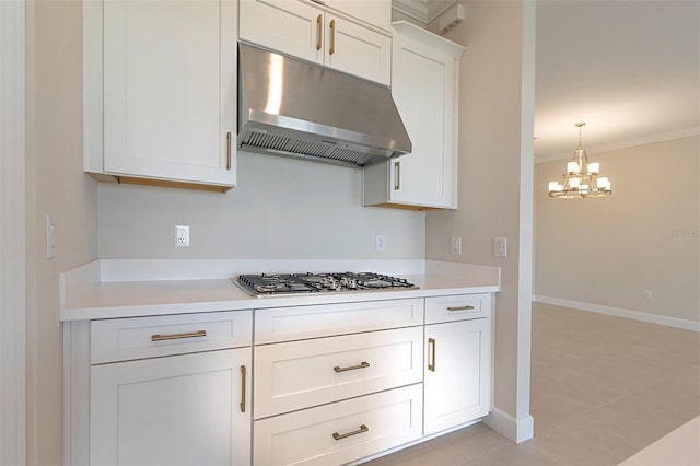 kitchen featuring light tile patterned floors, an inviting chandelier, crown molding, stainless steel gas stovetop, and white cabinets