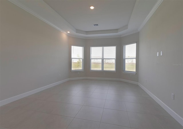 tiled spare room with a raised ceiling and ornamental molding