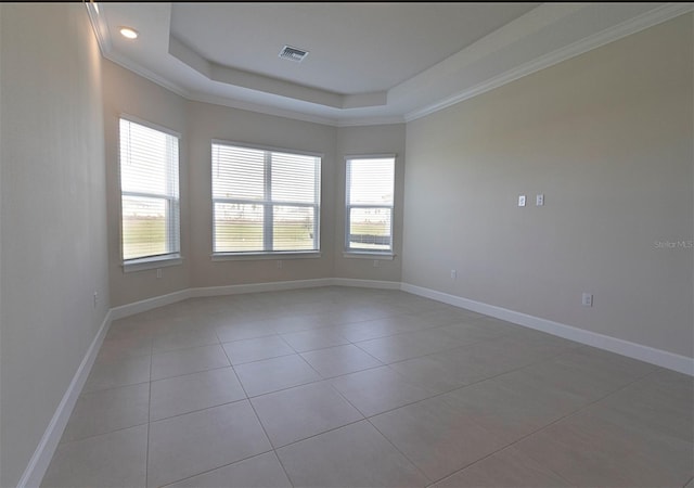 spare room featuring light tile patterned floors, a raised ceiling, and ornamental molding