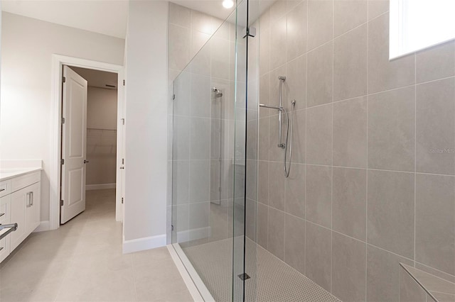 bathroom with a tile shower, tile patterned floors, and vanity