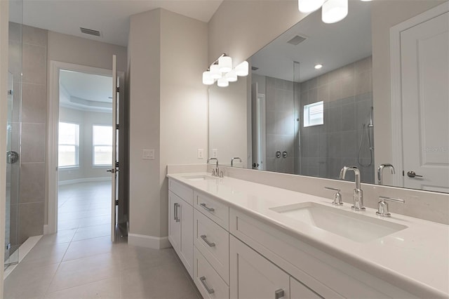 bathroom with a tray ceiling, tile patterned flooring, vanity, and a shower with shower door