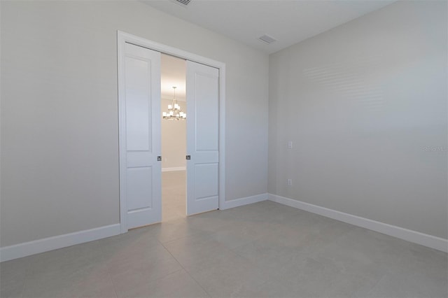 unfurnished room with a notable chandelier