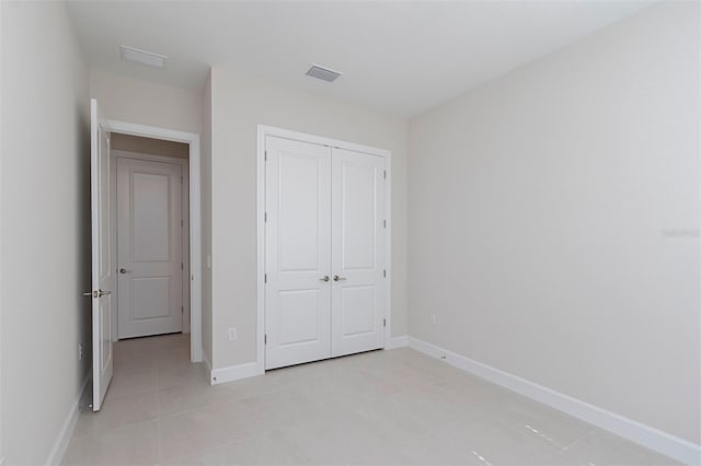 unfurnished bedroom with light tile patterned floors and a closet