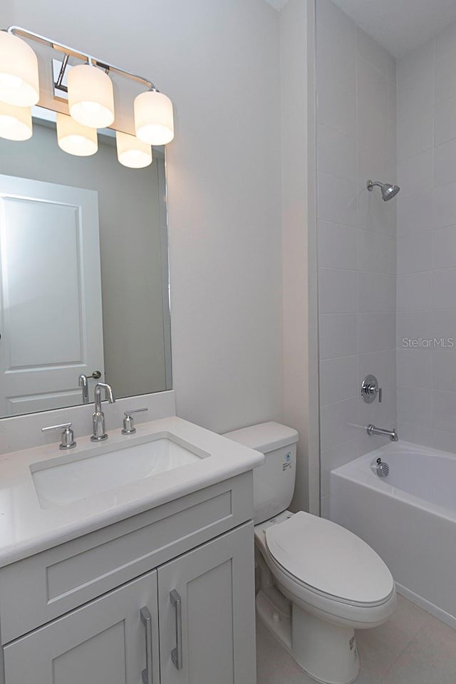 full bathroom featuring tile patterned flooring, vanity, toilet, and tiled shower / bath