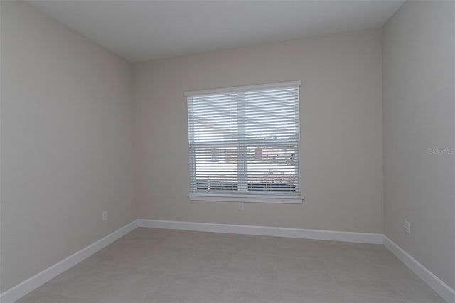 empty room with a wealth of natural light and light tile patterned flooring