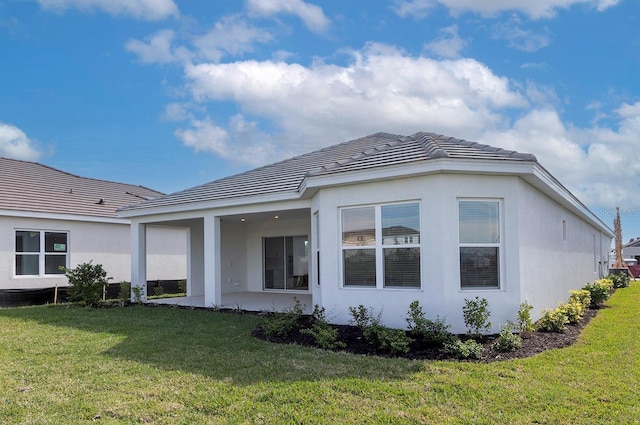 rear view of property with a lawn and a patio