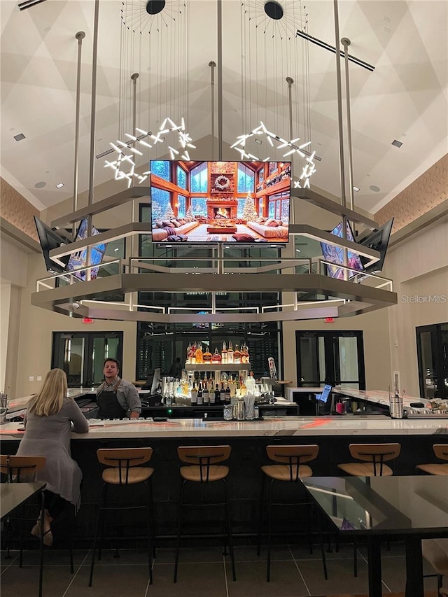 bar with tile patterned flooring and a high ceiling