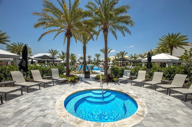 view of swimming pool featuring a patio and a hot tub