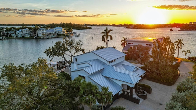 aerial view at dusk featuring a water view