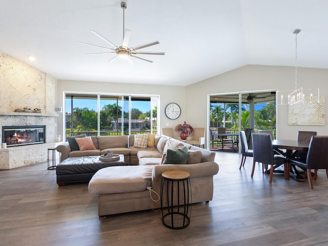 living room featuring a fireplace, dark hardwood / wood-style flooring, ceiling fan with notable chandelier, and lofted ceiling