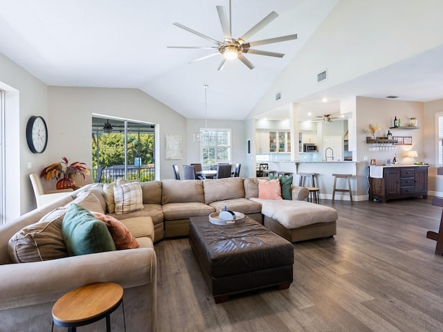 living room with dark hardwood / wood-style floors, vaulted ceiling, and sink