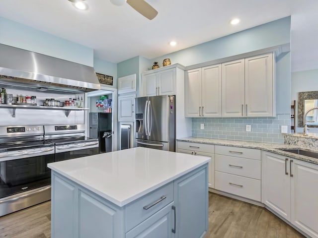 kitchen with light wood-type flooring, white cabinetry, sink, and appliances with stainless steel finishes