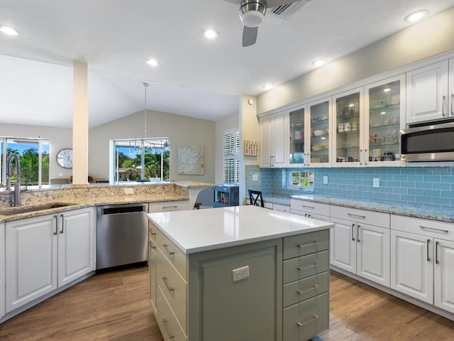 kitchen featuring appliances with stainless steel finishes, white cabinetry, a kitchen island, and sink