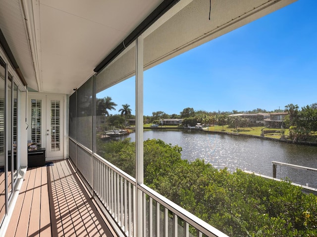 balcony featuring french doors and a water view