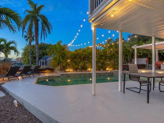 pool at dusk featuring a patio